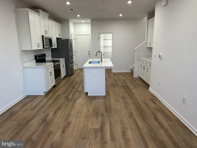 a kitchen with a sink refrigerator and microwave