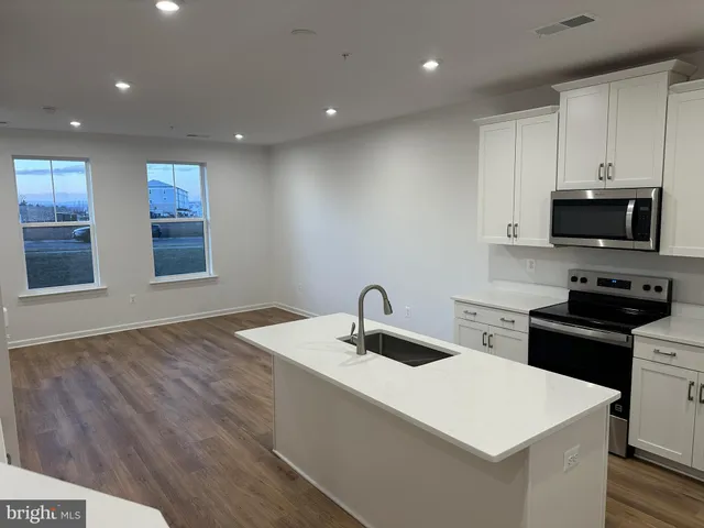 a kitchen with kitchen island a sink stainless steel appliances and window