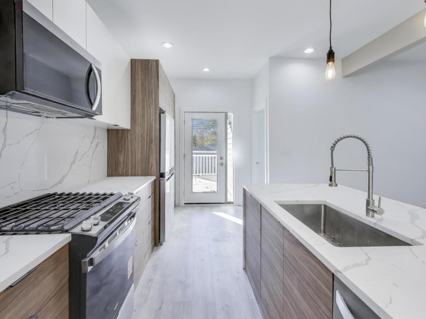 1721 West Arthur Avenue Chicago, IL 60626 - Photo 7 of 26 a kitchen with stainless steel appliances granite countertop a sink a stove and a refrigerator