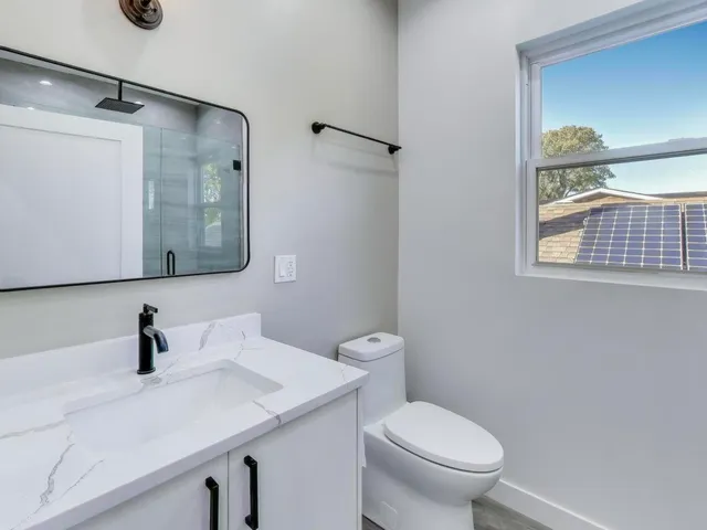 a bathroom with a sink a toilet and shower