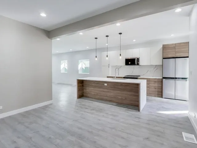 a large kitchen with kitchen island a sink stainless steel appliances and cabinets
