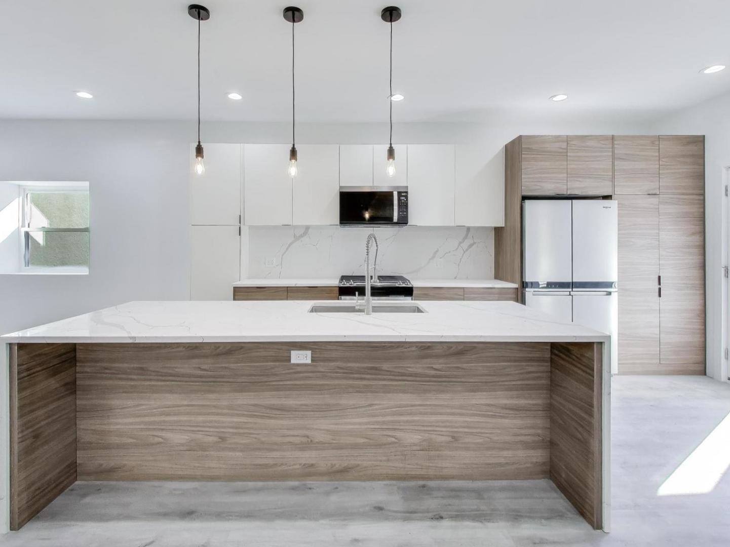 1721 West Arthur Avenue Chicago, IL 60626 - Photo 6 of 26 a view of a kitchen with kitchen island a sink stainless steel appliances and a chandelier