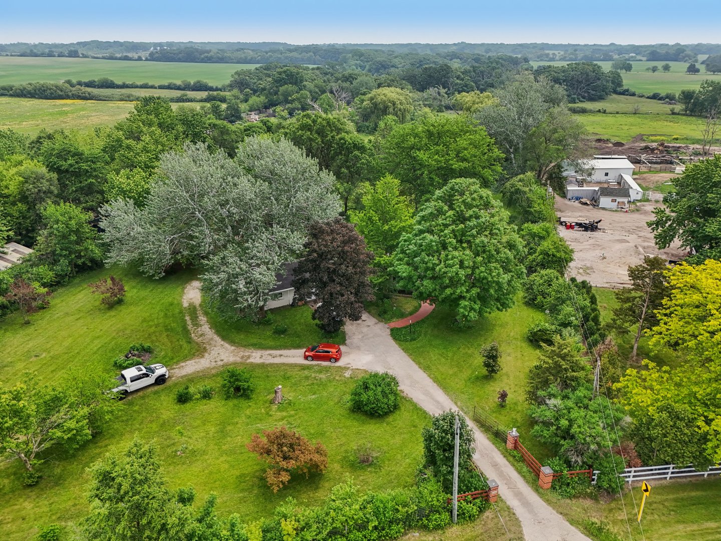 20214 Harmony Road Marengo, IL 60152 - Photo 47 of 56 an aerial view of green landscape with trees houses and lake view