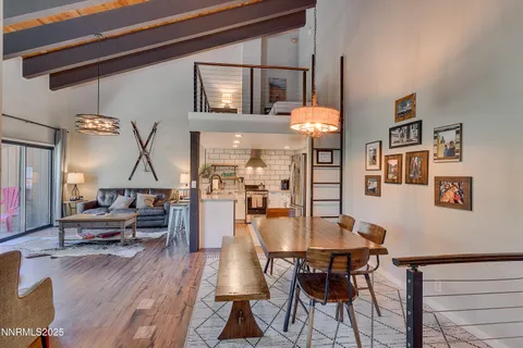 a dining room with wooden floor and large windows