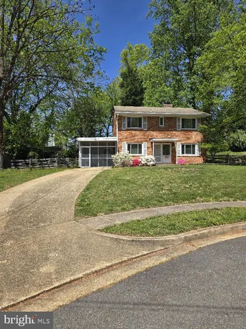 a view of a house with a big yard and large trees