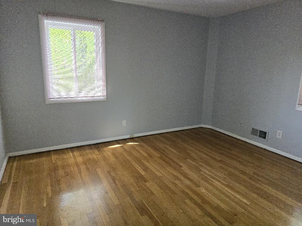7612 Clive Place Springfield, VA 22151 - Photo 13 of 23 a view of an empty room with wooden floor and a window