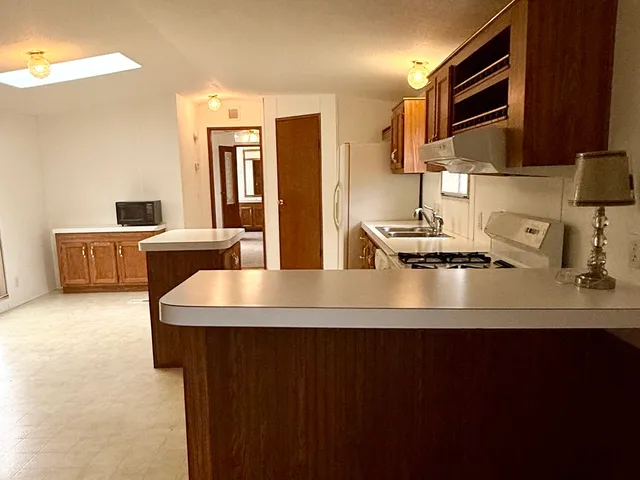 a kitchen with stainless steel appliances a sink stove and microwave
