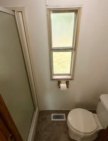 a white toilet sitting next to a window