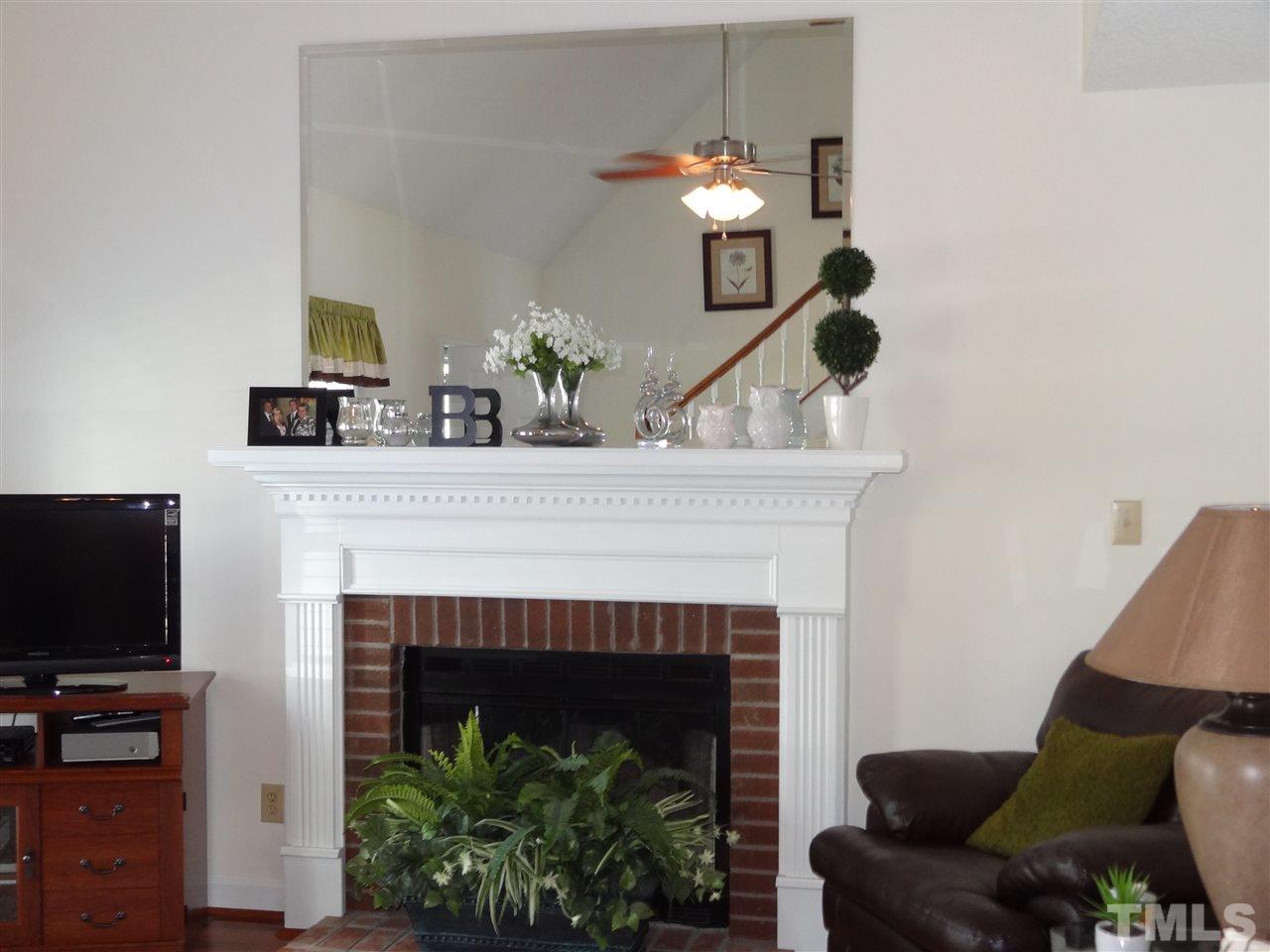 4416 Bartholomew Circle Raleigh, NC 27604 - Photo 5 of 24 a living room with furniture a fireplace and a flat screen tv
