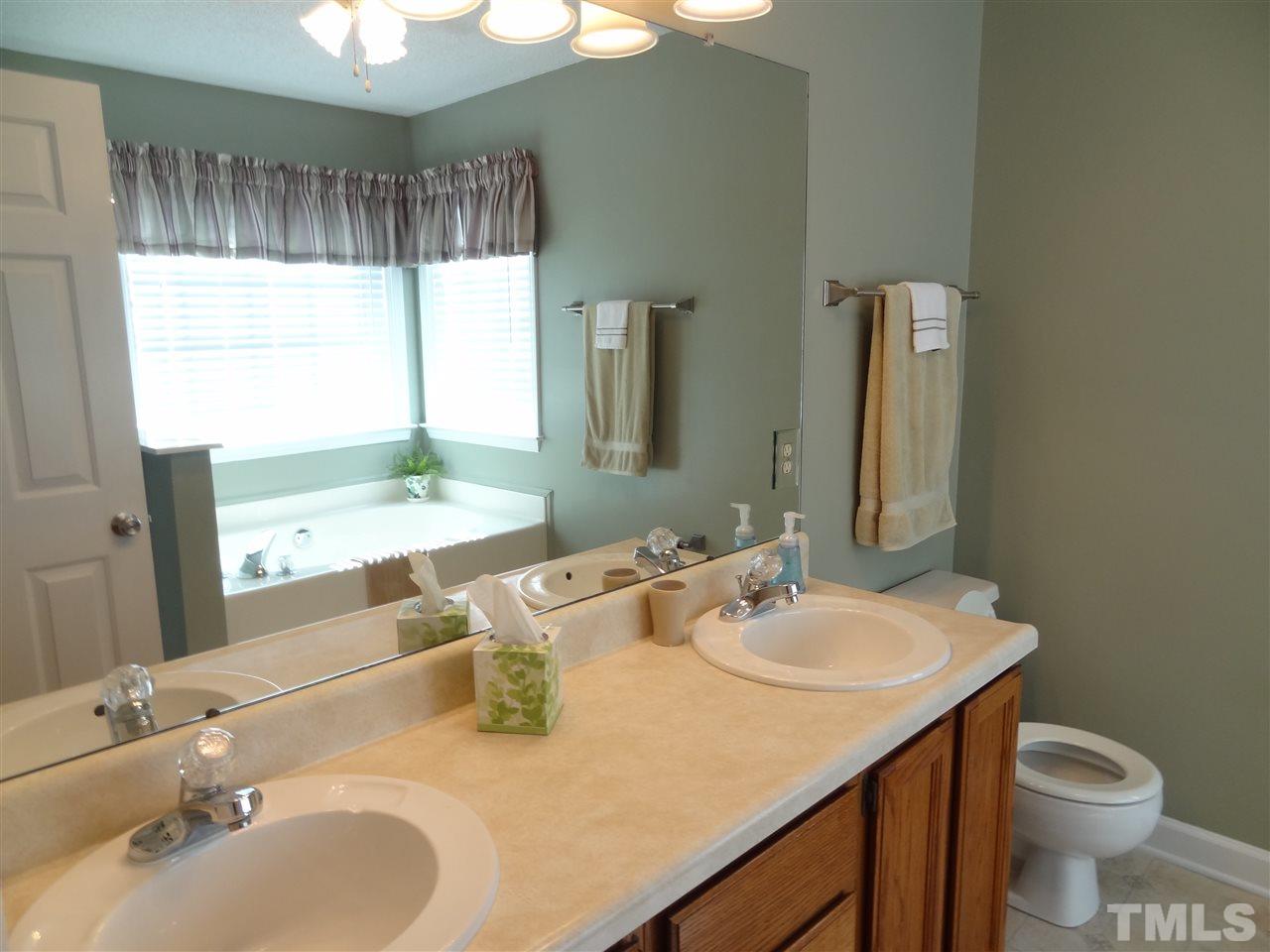 4416 Bartholomew Circle Raleigh, NC 27604 - Photo 8 of 24 a bathroom with a granite countertop sink and a mirror with toilet