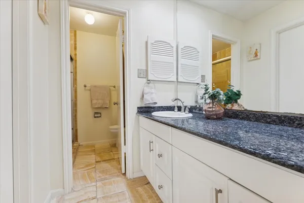 a bathroom with a granite countertop sink and a mirror