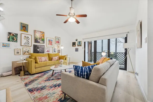 a living room with furniture ceiling fan and a rug