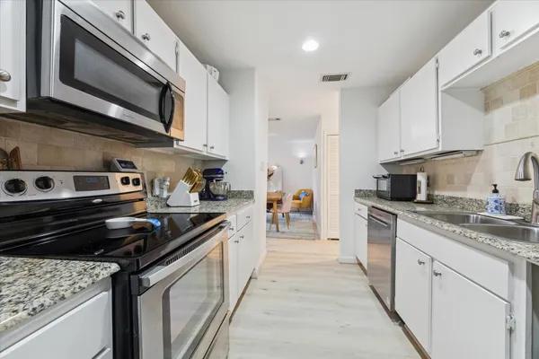 a kitchen with stainless steel appliances granite countertop a stove and a microwave