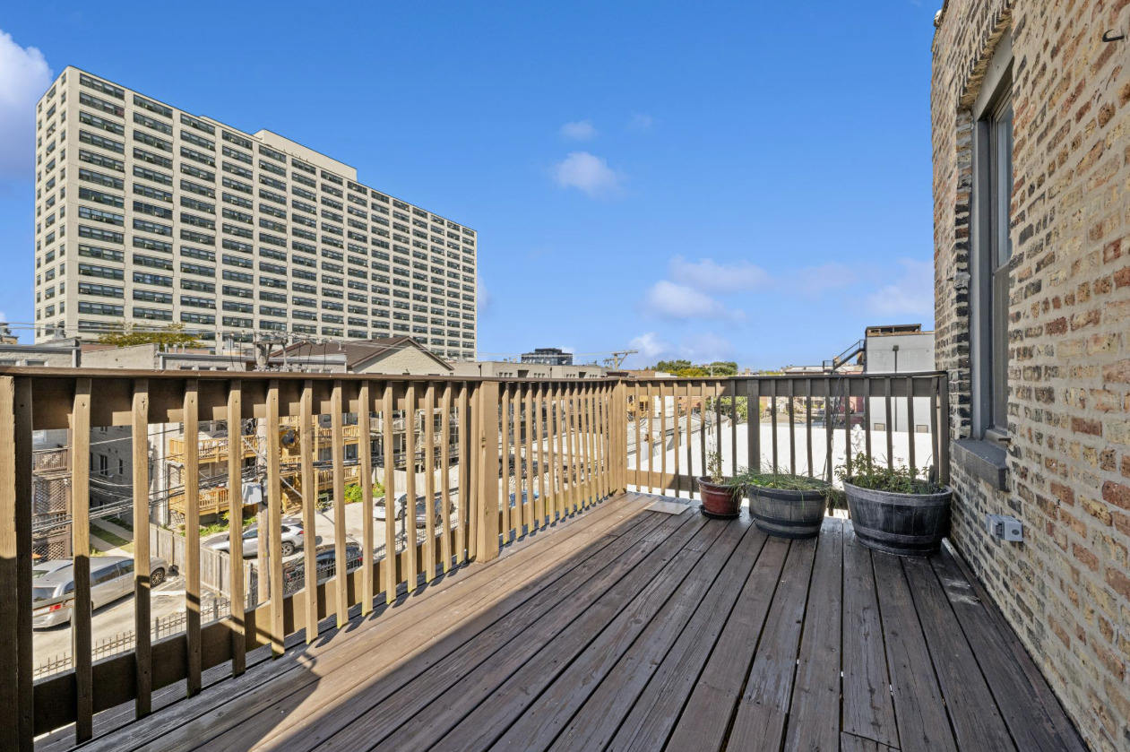 4834 North Kenmore Avenue, Unit 3N Chicago, IL 60640 - Photo 20 of 28 a balcony with wooden floor and fence