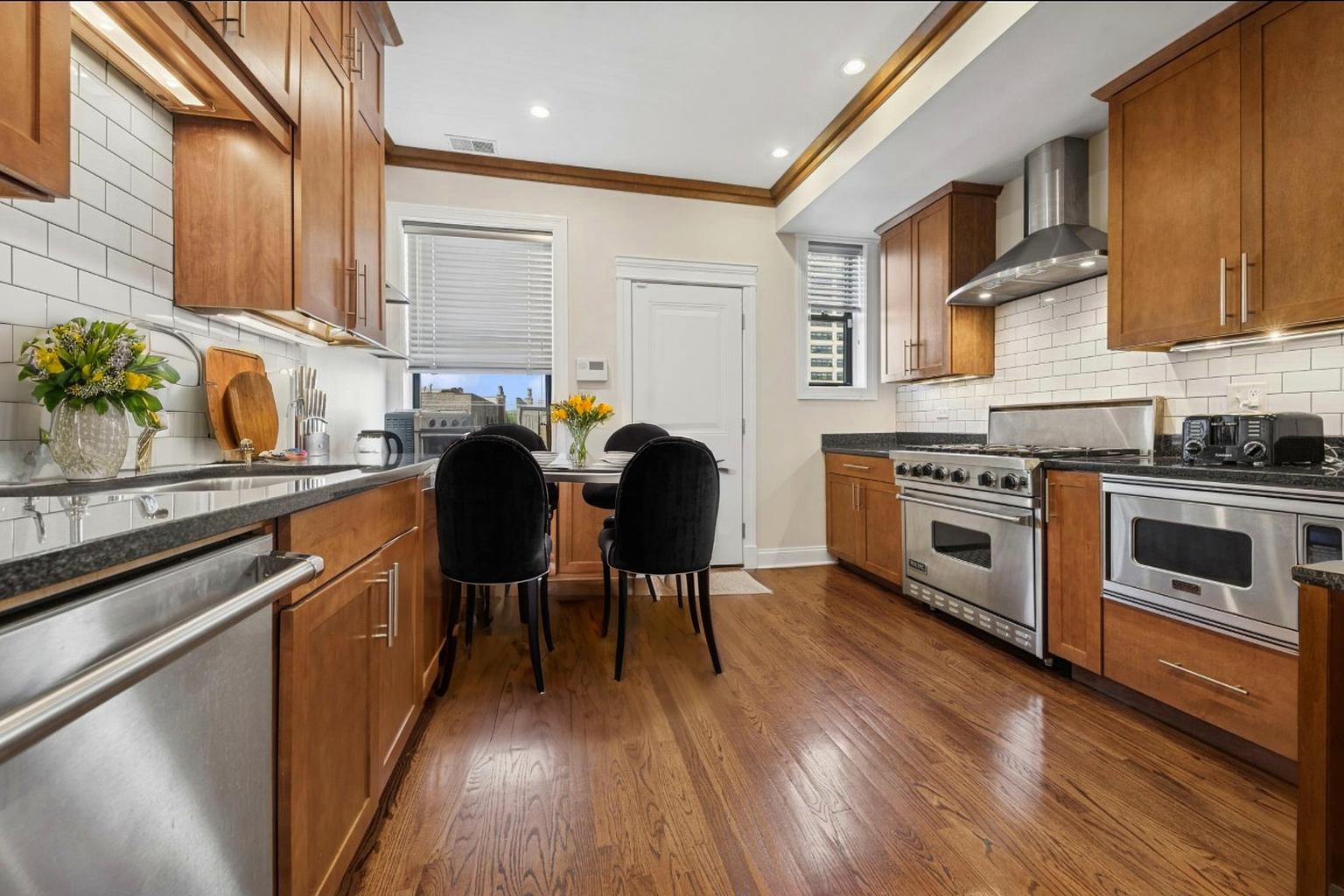 4834 North Kenmore Avenue, Unit 3N Chicago, IL 60640 - Photo 6 of 28 a kitchen with stainless steel appliances a stove a sink dishwasher and microwave with wooden floor