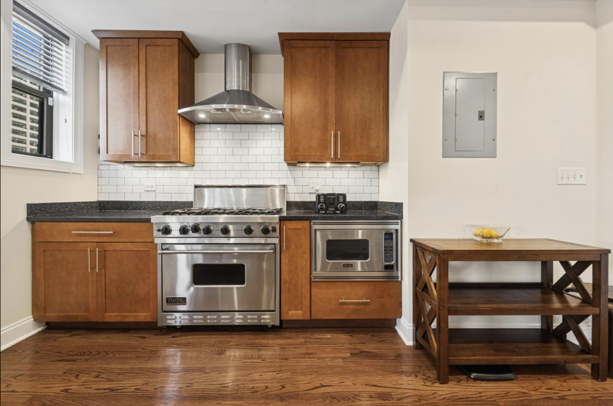4834 North Kenmore Avenue, Unit 3N Chicago, IL 60640 - Photo 8 of 28 a kitchen with granite countertop a stove and a wooden floors