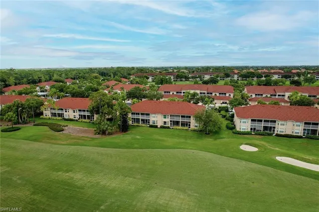 an aerial view of residential houses with outdoor space and trees