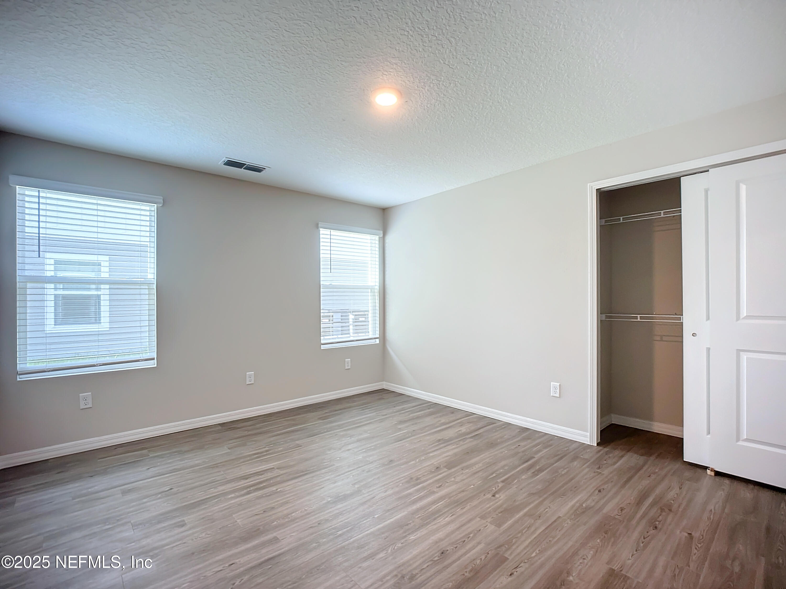 9612 Hood Road Jacksonville, FL 32257 - Photo 12 of 20 an empty room with wooden floor and windows