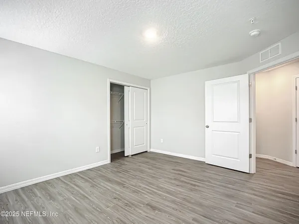 a view of an empty room with wooden floor