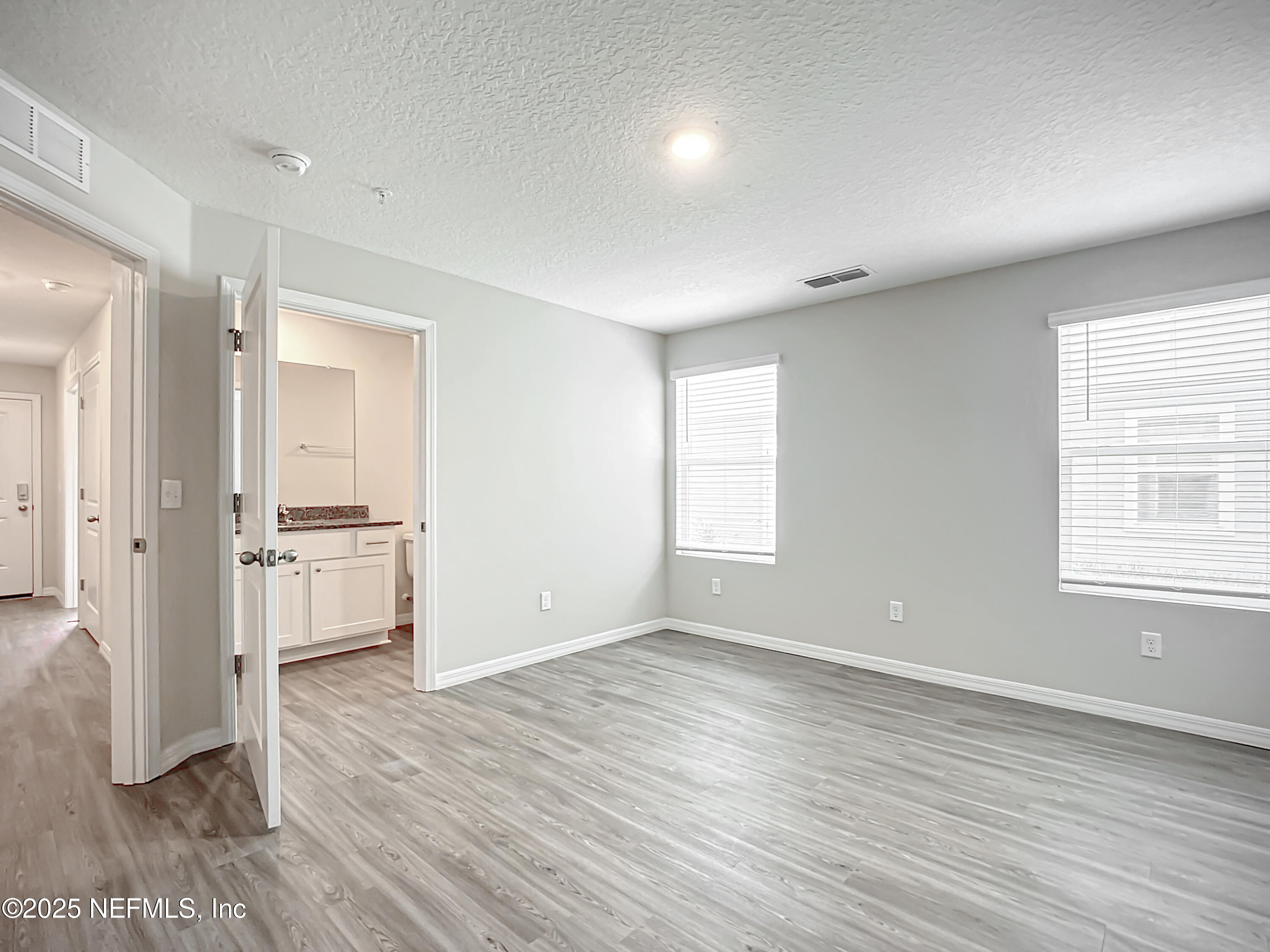 9612 Hood Road Jacksonville, FL 32257 - Photo 16 of 20 an empty room with wooden floor and windows