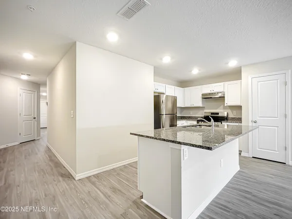 a kitchen with stainless steel appliances granite countertop a refrigerator and a sink
