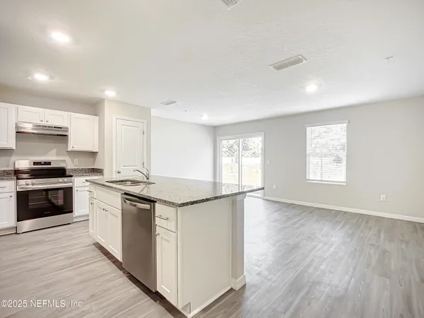 a kitchen with granite countertop a stove and a sink