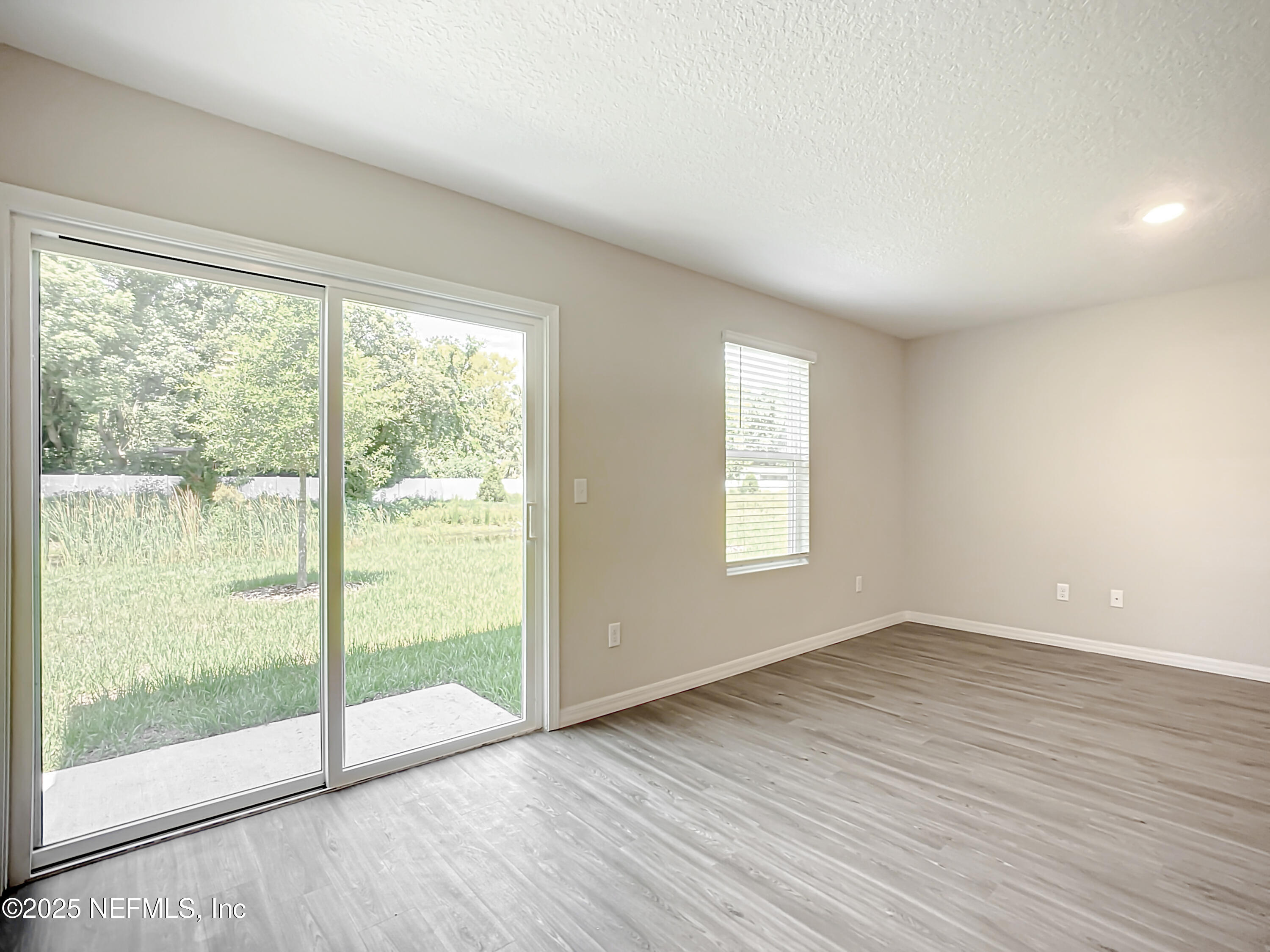 9612 Hood Road Jacksonville, FL 32257 - Photo 9 of 20 an empty room with wooden floor and windows