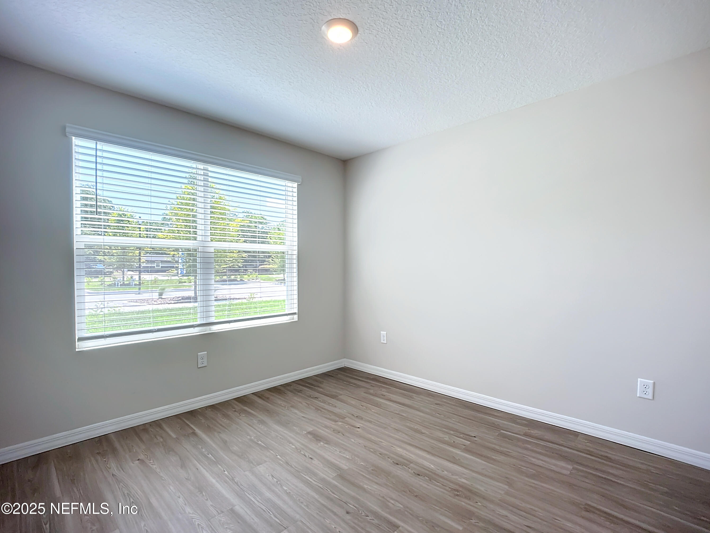 9612 Hood Road Jacksonville, FL 32257 - Photo 10 of 20 an empty room with wooden floor and windows