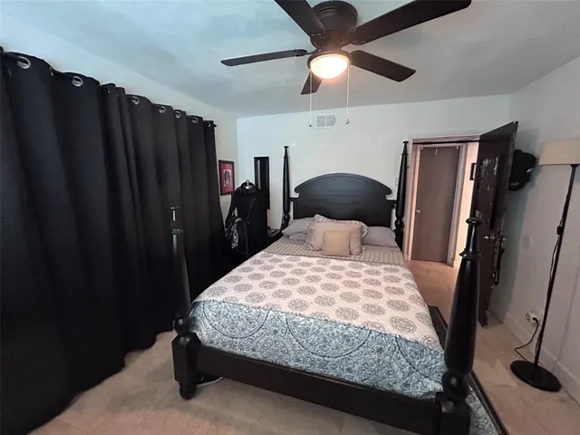 a bedroom with a bed and a mirror on the dresser