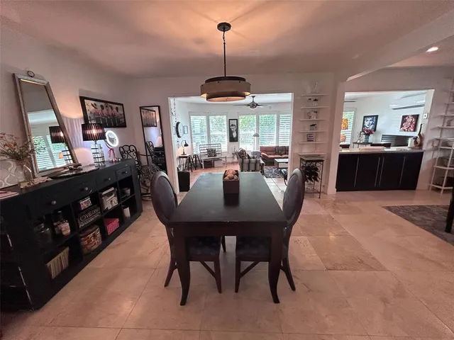 a kitchen with stainless steel appliances granite countertop a stove a sink dishwasher a dining table and chairs with wooden floor