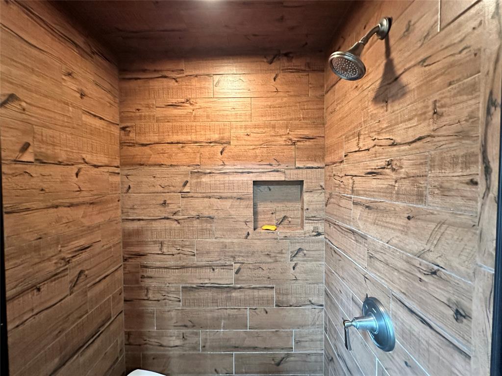 11001 West Lake Road Abilene, TX 79601 - Photo 33 of 40 Bathroom with wooden walls and tiled shower