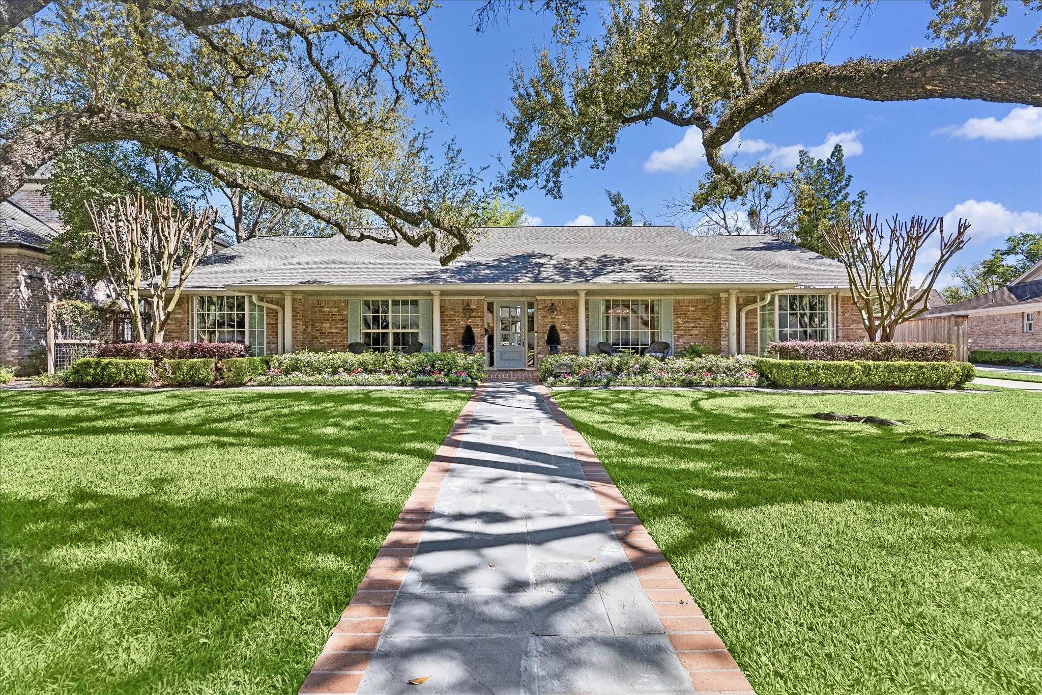 907 Wild Valley Road Houston, TX 77057 - Photo 1 of 31 a front view of a house with a yard table and chairs