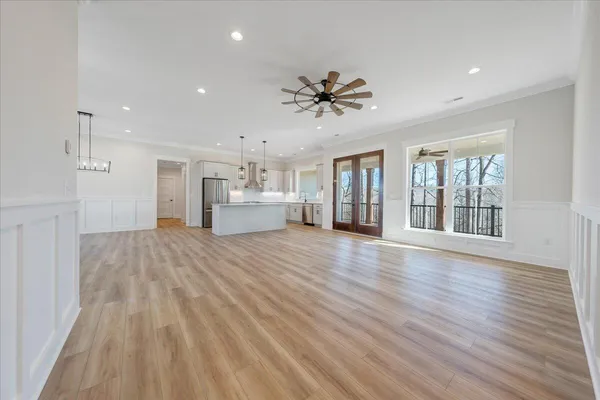 a view of an empty room with window and wooden floor