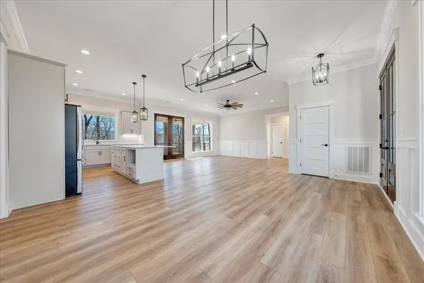 a living room with furniture kitchen view and a chandelier