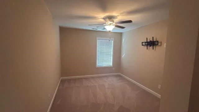 a view of room with a ceiling fan and a window