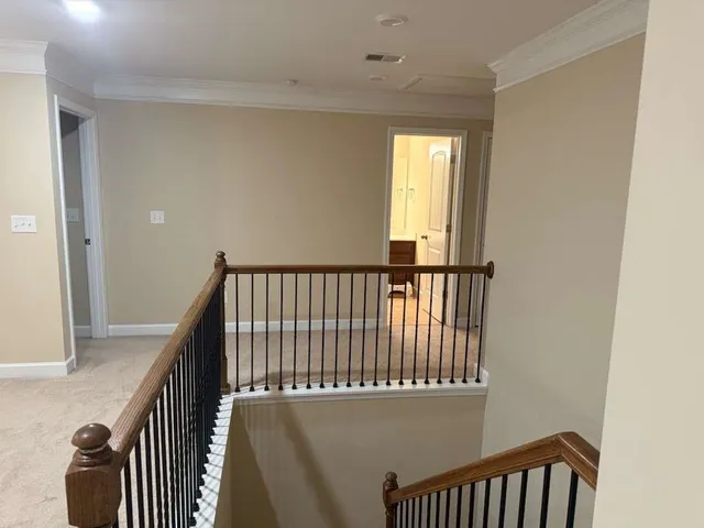a view of staircase with railing and white walls