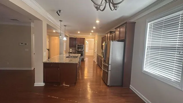 a kitchen with stainless steel appliances granite countertop a refrigerator a sink and a stove