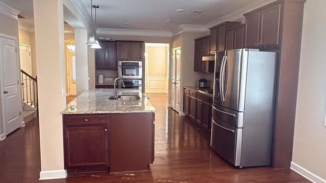 a kitchen with stainless steel appliances a refrigerator and wooden cabinets