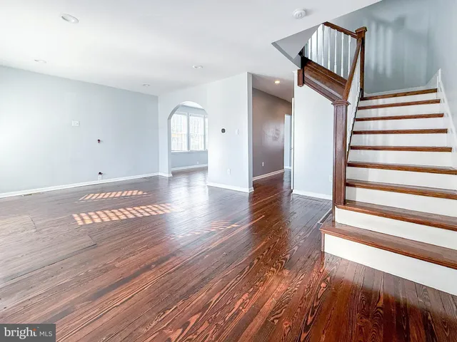 a view of a hallway with wooden floor and stairs