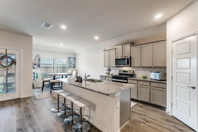 a large kitchen with sink cabinets and wooden floor