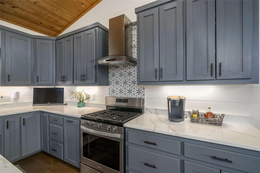 454 North Old Aska Road Blue Ridge, GA 30513 - Photo 12 of 33 a kitchen with stainless steel appliances granite countertop wooden cabinets and a stove top oven