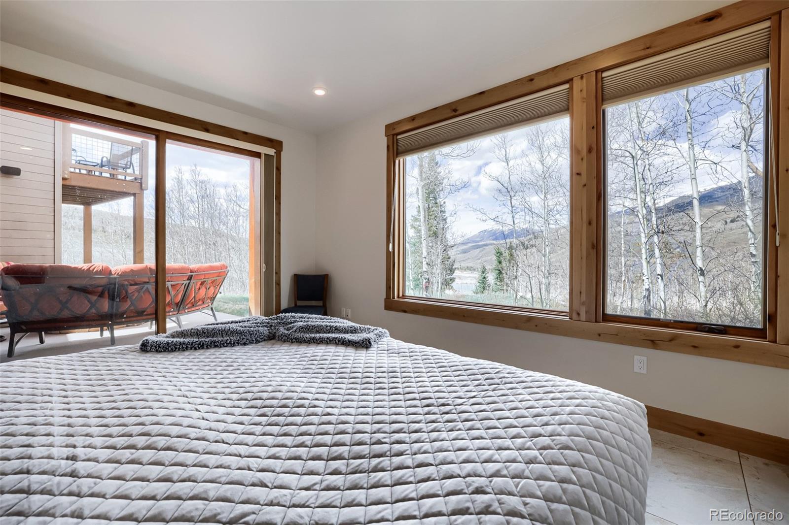 836 Maryland Creek Road Silverthorne, CO 80498 - Photo 19 of 49 a bedroom with a bed and glass windows
