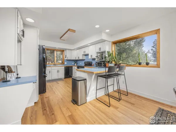 a living room with stainless steel appliances kitchen island granite countertop furniture and a large window