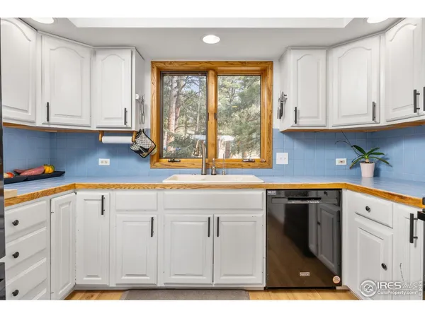 a kitchen with stainless steel appliances granite countertop a sink window and cabinets