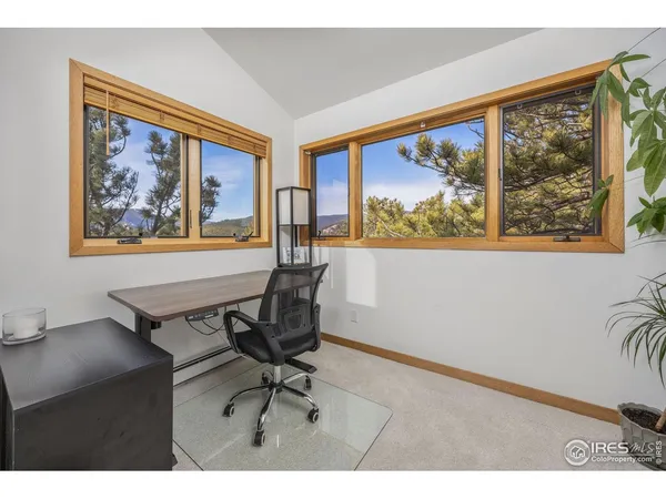 a view of a workspace with furniture and a window