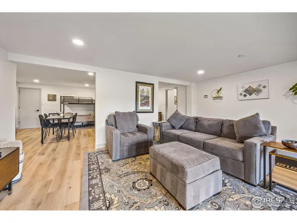 a living room with furniture wooden floor and a dining table