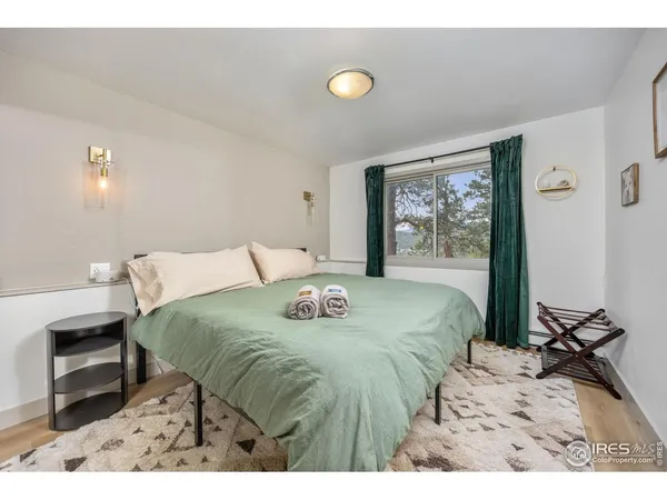 a bedroom with a bed and a flat tv screen on the dresser