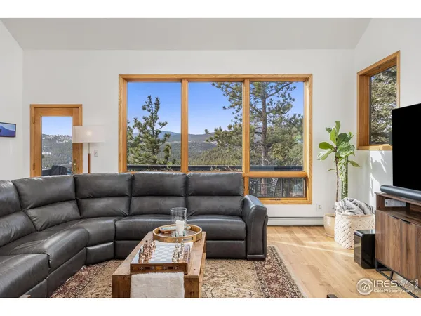 a living room with furniture a flat screen tv and a large window