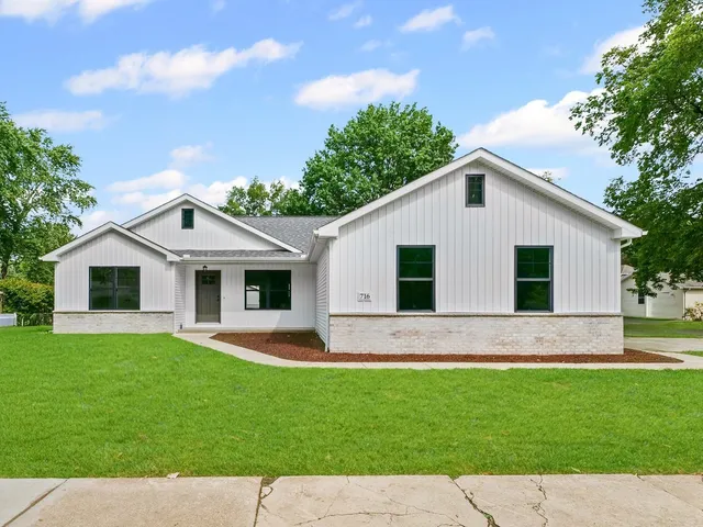 a front view of house with a garden