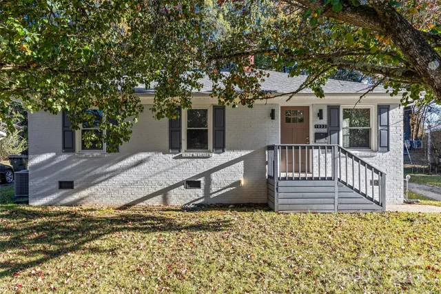 a view of a house with a yard and wooden fence